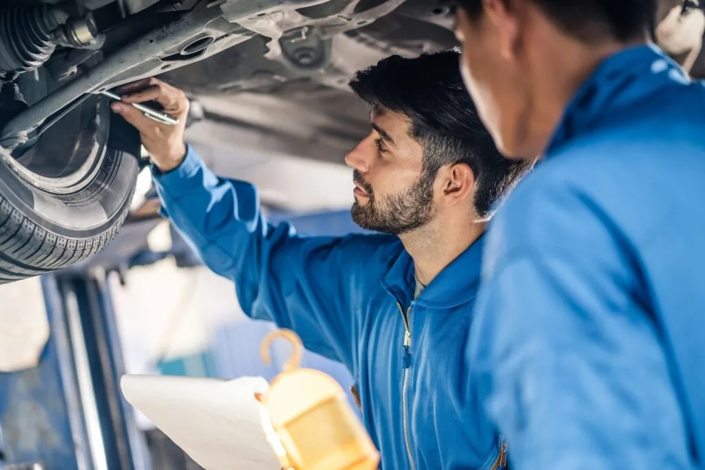 vehicle-service-maintenance-handsome-mens-checking-under-car-condition-in-garage-.jpg